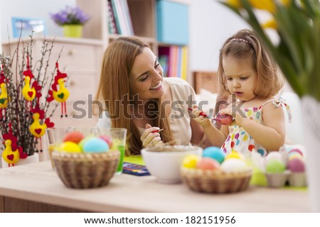 Mother and baby painting easter eggs