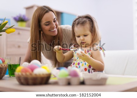Family playing during painting easter eggs