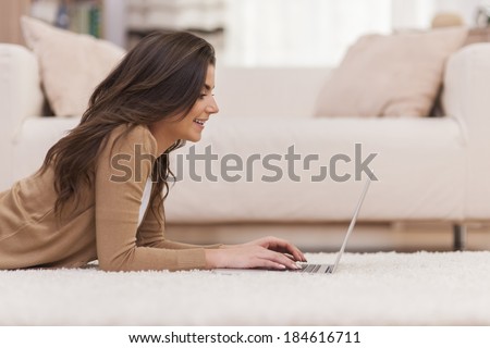 Happy woman surfing the net at home