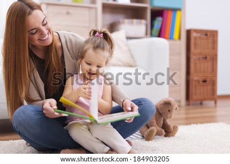 Mother and child reading book at home