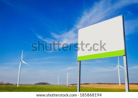Blank board on area with energy windmills