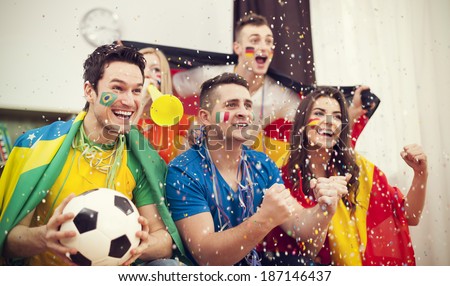 Multinational football supporters celebrating goal