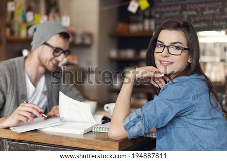 Stylish woman studying with her friend at cafe
