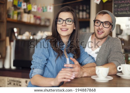 Hipster couple talking with friends at cafe