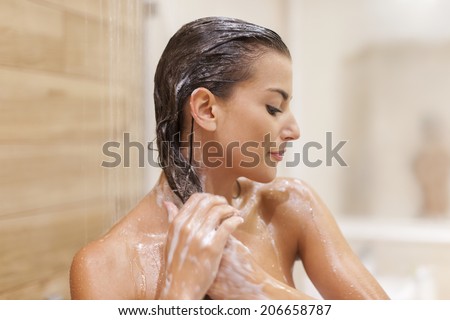 Woman washing hair under shower