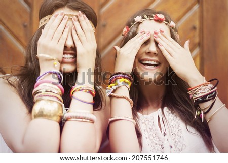 Boho girls covering eyes by hands