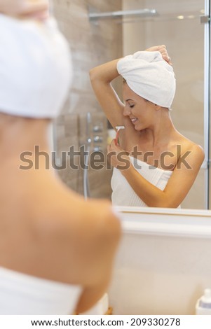 Woman shaving armpit after the shower