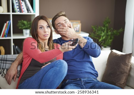 Shocked couple watching scary movie