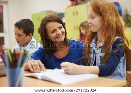 Teacher helping her cute pupil