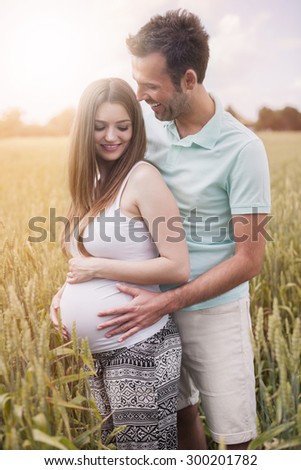 Pregnant woman and his husband on the field