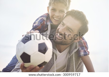 Father teaches son how to play football