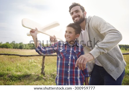 Father and son testing a paper plane