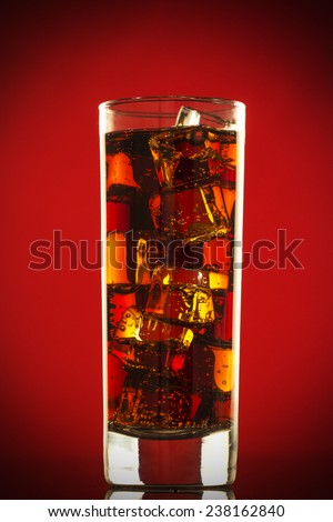 cola with ice on red background