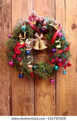 Christmas wreath with golden bells on the wooden background