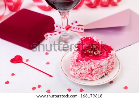Valentine day still-life with cake, glass of wine, gift box and decorations