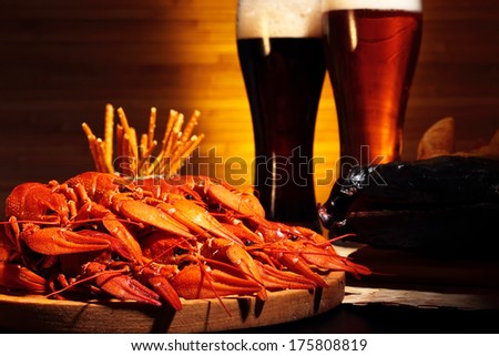 Glasses of dark and light beer with crawfish and smoked fish