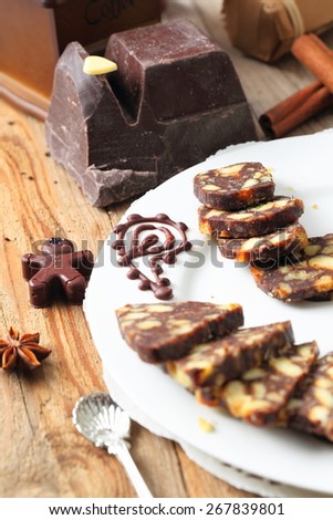 sliced chocolate sausage with various decorations on a wooden table