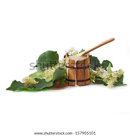 Natural linden honey in the wooden cask with linden blossoms isolated on white