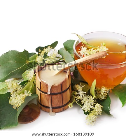 Natural linden honey in the wooden cask with linden blossoms isolated on white