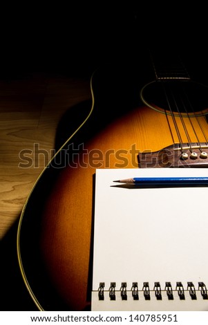 close-up Notebook and pencil on guitar,Writing music