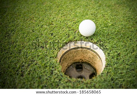 golf ball on lip of golf hole