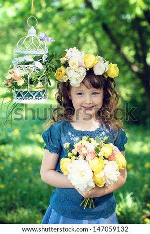 Girl with fresh flowers in her hair  holding a bouquet of flowers, smilling
