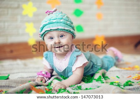 baby in knitted cap on his head, lying on the carpet