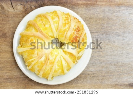 Pineapple bread in white plate on wood table