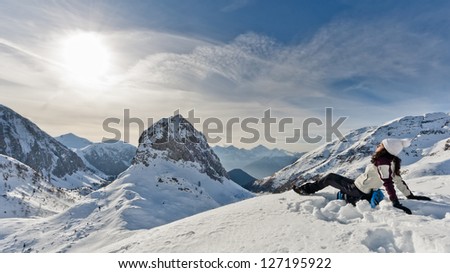 Sunbathing on the snow (A): A girl sunbathing and relaxing on the top of a mountain in the Italian Alps after a strenuous hike with snow shoes.