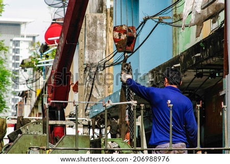 Thai man worker with equipment crane moving the machine