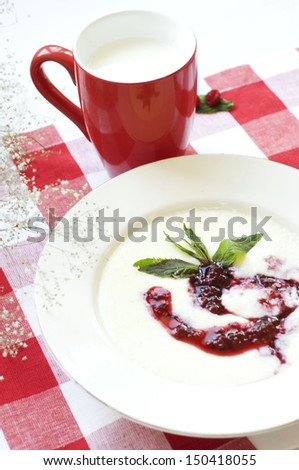 semolina pudding cooked on milk with raspberry jam and a cup of milk