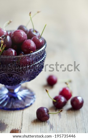 crystal bowl of cherries on a wooden table