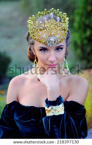 Elegant young woman dressed like queen with a crown