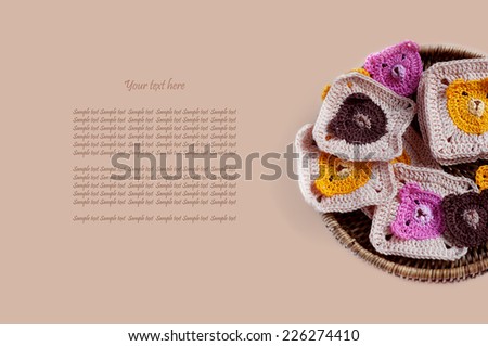 Box of crocheted square pattern motives on beige background with sample text