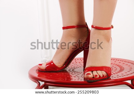 Woman\'s bare feet in red peep-toes close up