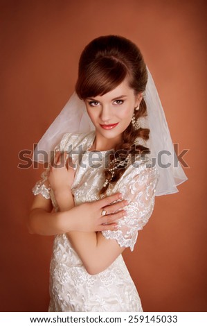 Beautiful young bride with retro hairstyle, back combing, pearl hair decoration and a veil