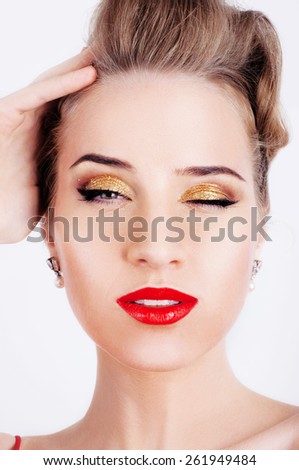 Beautiful sexy blonde woman with party makeup and red lips winking