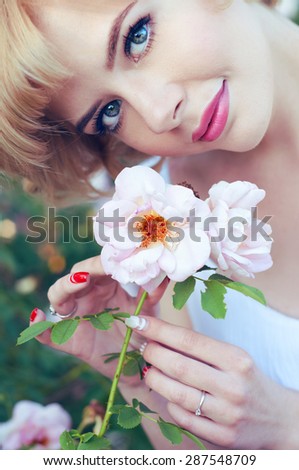 Beautiful blonde woman with pink lips holding a white rose
