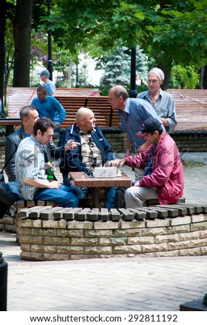 KYIV, UKRAINE - JULY 2015 -   men play chess in the yard. A group of men play chess outdoor and have a heated discussion in the yard near Taras Shevchenko National University of Kyiv.