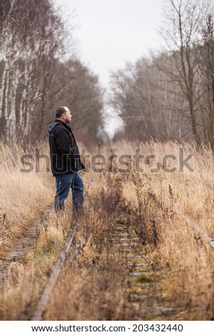 Middle aged man is walking along abandoned railway tracks/Looking Back at the Way of Life
