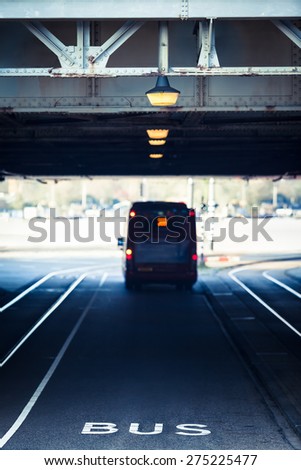 Dedicated bus lane under a steel girder bridge with illuminated streetlights/Steel Beam Road Tunnel