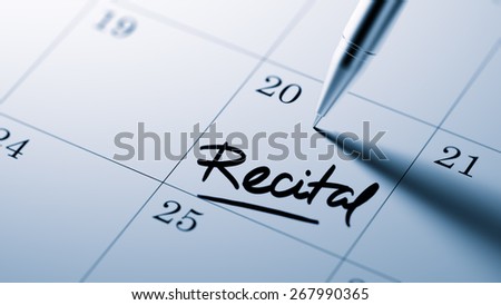 Closeup of a personal agenda with a Ballpoint pen marking a day of the month representing a organizing time and schedule. Recital text note reminder concept. Words Recital written in Black Marker.