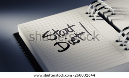 Closeup of a personal agenda marking a day of the month representing a organizing time and schedule. Start Diet text note reminder concept. Words Start Diet written in Black Marker.