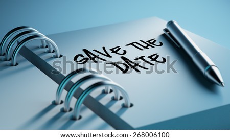Closeup of a personal agenda with a Ballpoint pen marking a day of the month representing a schedule. Save the date text note reminder concept. Words Save the date written in Black Marker.