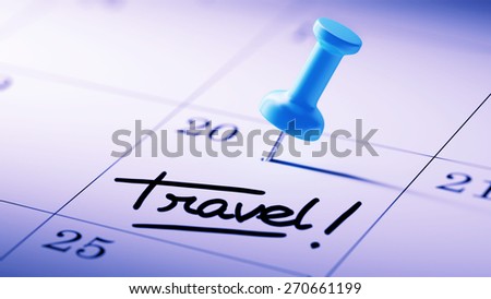 Concept image of a Calendar with a blue push pin. Closeup shot of a thumbtack attached. The words Travel written on a white notebook to remind you an important appointment.