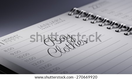 Closeup of a personal calendar setting an important date representing a time schedule. The words Buy Clothes written on a white notebook to remind you an important appointment.