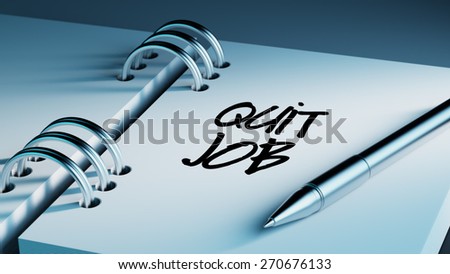 Closeup of a personal agenda setting an important date writing with pen. The words Quit job written on a white notebook to remind you an important appointment.
