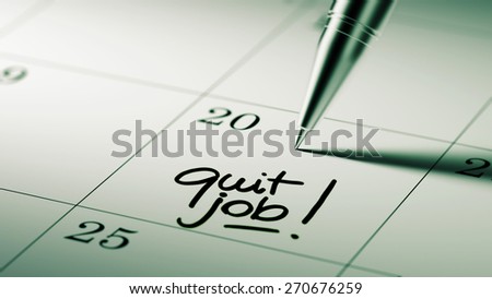 Closeup of a personal agenda setting an important date written with pen. The words Quit job written on a white notebook to remind you an important appointment.