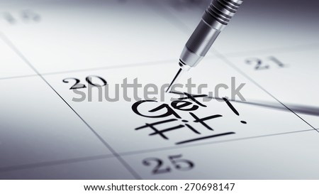 Concept image of a Calendar with a golden dart stick. The words Get Fit! written on a white notebook to remind you an important appointment.