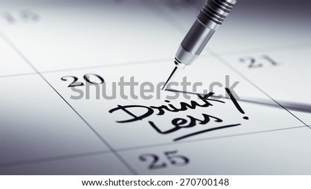 Concept image of a Calendar with a golden dart stick. The words Drink Less written on a white notebook to remind you an important appointment.